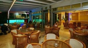 a restaurant with tables and chairs and people in the background at Kleopatra Celine Hotel in Alanya