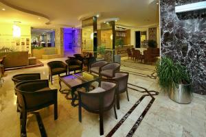 a lobby with chairs and tables in a building at Kleopatra Celine Hotel in Alanya