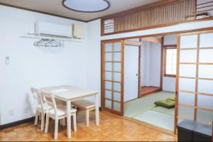 a dining room with a table and chairs at ゲストハウス蔵 in Shimonoseki