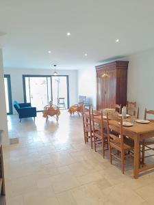 a living room with a wooden table and chairs at La maison du Sophora grande maison 3 chambres in Saint-Didier-de-Formans