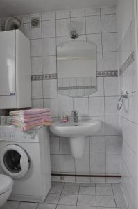 W białej łazience znajduje się umywalka i lustro. w obiekcie Miód Malina w Nałęczowie