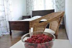 ナウェンチュフにあるMiód Malinaの寝室のテーブルにイチゴを盛り付けた鉢