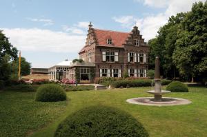 een groot gebouw met een fontein in het midden van een tuin bij Hotel Huys ter Schelde in Koudekerke