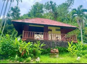 een klein huis met een rood dak in een bos bij Harmony Home in Hang Dong +3 foto's