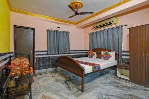 a bedroom with a bed and a ceiling fan at FabHotel Relyef Inn in kolkata