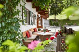 a patio with couches and a table and flowers at Landsitz Römerhof - Hotel Apartments in Kitzbühel