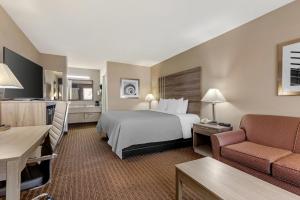 a large hotel room with a bed and a couch at Quality Inn Paris Texas in Paris