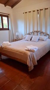 1 cama grande en un dormitorio con cortinas en Cabañas lodge El Suizo, en Gobernador Virasora