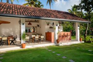 a patio with tables and chairs and a yard at SĀMA Ahangama in Ahangama