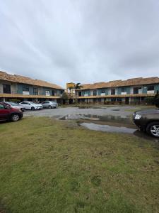 a parking lot with cars parked in front of a building at Beachfront House with Pool and Gourmet Area in Rio das Ostras