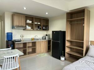 a kitchen with a black refrigerator freezer next to a couch at Mactan Plains Studio Unit in Punta Engaño