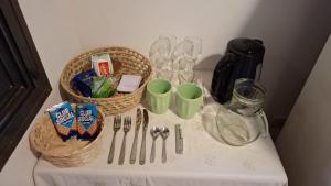 a table with baskets and cups and utensils on it at Cabañas Lodge el Suizo 2 in Gobernador Virasora