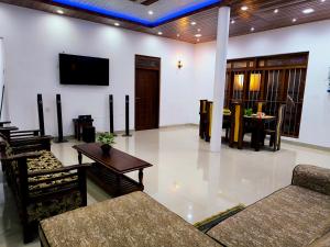 a living room with chairs and a tv on the wall at Freedom-Inn Resort Villa in Tangalle