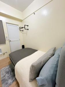 a bedroom with a bed and a flat screen tv at CoZerenity Stays Minimalist Condo in Naga City in Naga