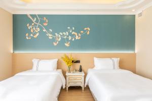 広州市にある广州维福顿白宫酒店の部屋に並んで置かれた2つのベッド