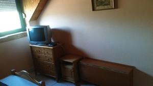 a room with a tv on top of a dresser at Magdi apartman in Pusztavacs