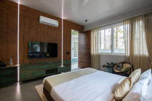 una camera da letto con un letto e una TV a schermo piatto di The Amberle Resort a Yelagiri