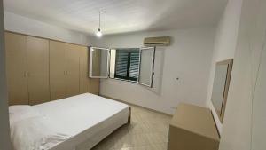 a bedroom with a white bed and a window at Blue Wave Apartment in Orikum