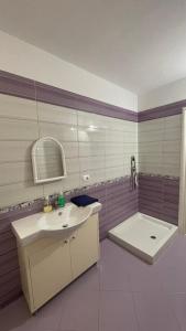 a bathroom with a sink and a tub and a toilet at Blue Wave Apartment in Orikum +10 photos
