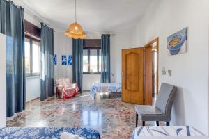 a living room with a couch and a chair and windows at Villetta Municipio - Salento in Castrignano del Capo