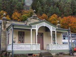 a small house with a white porch and an arch at Eikon Apartments Abastumani in Abastumani