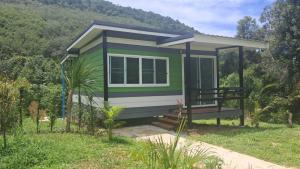 una piccola casa verde con una collina sullo sfondo di Greenview Room and Restaurant  Altre 5 foto