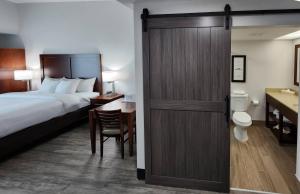 a hotel room with a bed and a sliding door at Comfort Suites Baymeadows Near Butler Blvd in Jacksonville +39 photos