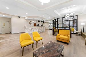 a living room with yellow chairs and a table at Comfort Suites Augusta Riverwatch in Augusta +75 photos