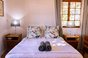 a bed with two pairs of shoes on top of it at Mountainside Family Beach House - Pet Friendly in Hermanus +29 photos