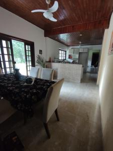 una sala da pranzo con tavolo e sedie e una cucina di Chácara da Felicidade Holing Hostel Conexão e cura interior! a Iguape Altre 20 foto