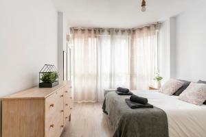 a bedroom with a bed and a dresser and a window at Santander Centro in Santander