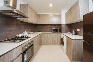 a kitchen with wooden cabinets and a stove top oven at Ten4teen Luxury Apartment in Galle