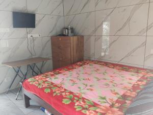 a bedroom with a bed with a red floral bedspread at Nachiyar Hotel in Kanthalloor