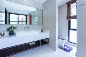 a white bathroom with a large sink and a mirror at Laguna Park Phuket in Bang Tao Beach +26 photos