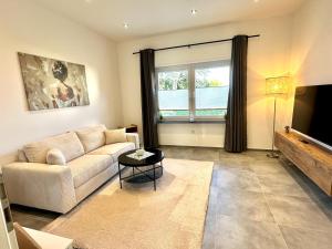 a living room with a couch and a television at Relax Home Eschweiler Sauna & Gemütlichkeit, WLAN, Netflix, Kingsize Betten, Enspannung in Eschweiler