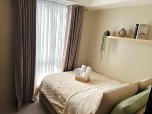 a bedroom with a bed with a window at Kasara Urban Residences in Pasig City - Solmera Cove in Manila