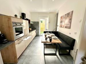 a kitchen with a table and a couch in a room at Relax Home Eschweiler Sauna & Gemütlichkeit, WLAN, Netflix, Kingsize Betten, Enspannung in Eschweiler