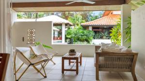 Una sala de estar con una mesa y sillas y una gran ventana. en Surya 7 Port Douglas, en Craiglie