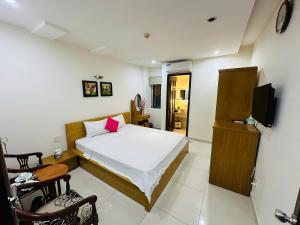 Un dormitorio con una cama, un escritorio y un televisor. en The Obsidian Sky Hanoi-Chic Loft with Rooftop Pool-Near Street Food, en Hanói