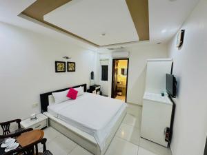 Un dormitorio con una cama blanca y un televisor. en The Obsidian Sky Hanoi-Chic Loft with Rooftop Pool-Near Street Food, en Hanói 29 fotos más