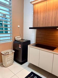 a kitchen with a trash can next to a counter at MU Homestay in Simpang Ampat +7 photos