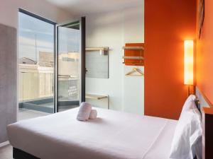 a bedroom with a large bed and a large window at Ibis Budget Madrid Centro Lavapies in Madrid