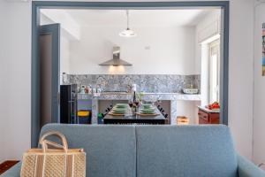 a living room with a blue couch and a kitchen at Villa Linda con Terrazzo in Giardini Naxos