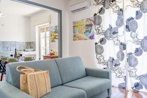 a blue couch in a living room with a mirror at Villa Linda con Terrazzo in Giardini Naxos +7 photos
