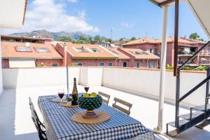 a table on a balcony with wine and wine glasses at Villa Linda con Terrazzo in Giardini Naxos