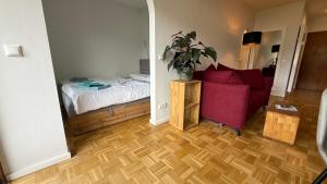 a bedroom with a bed and a red chair at Studio Bergblick 5 in Garmisch-Partenkirchen