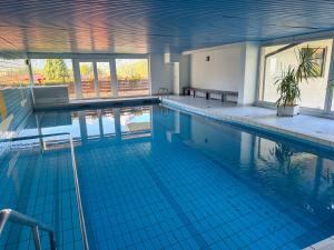 a large swimming pool with blue tiles in a building at Watzmann Juwel in Berchtesgaden
