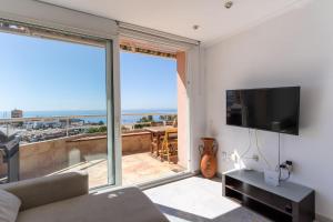 ein Wohnzimmer mit einem TV und einem großen Fenster in der Unterkunft Expoholidays - Puerto Aguadulce (Av Carlos III 432 3ºI) in Aguadulce
