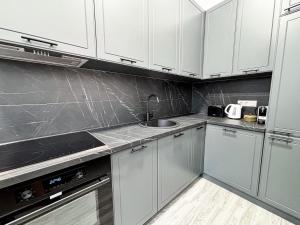 a kitchen with white cabinets and a sink at Sunset Mad Central Luxury Residence in Cluj-Napoca