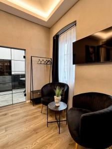 a living room with two chairs and a table at Sunset Mad Central Luxury Residence in Cluj-Napoca